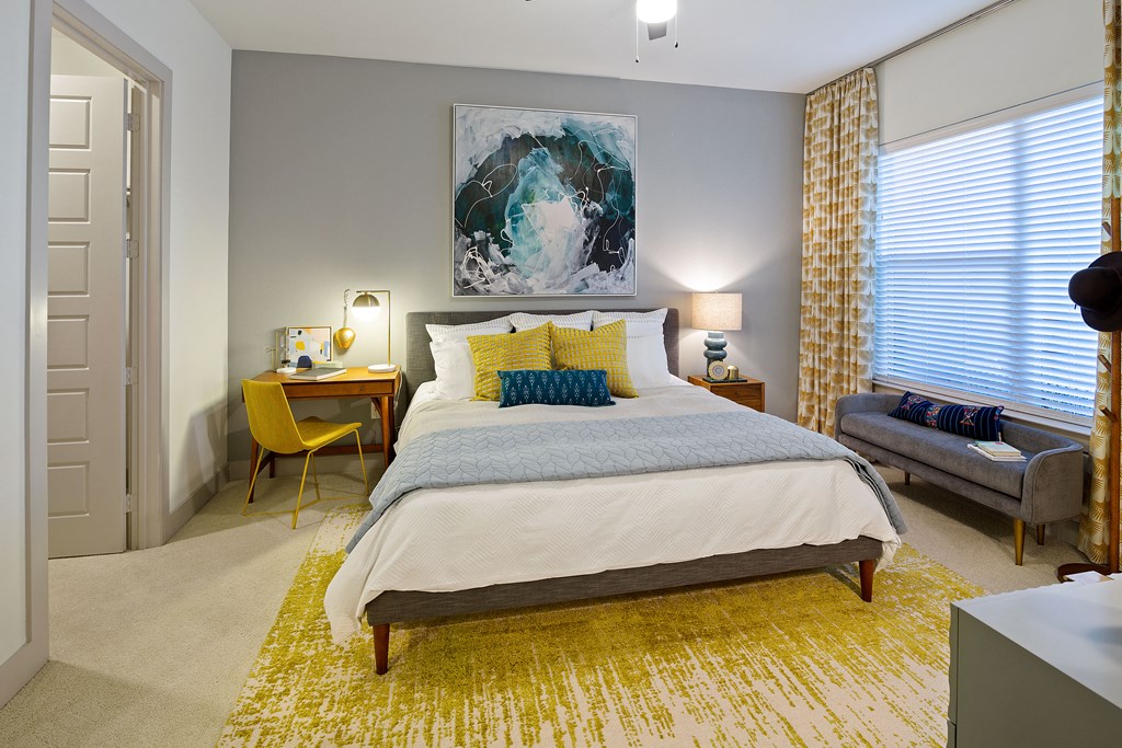 a bedroom with a large bed and a yellow rug