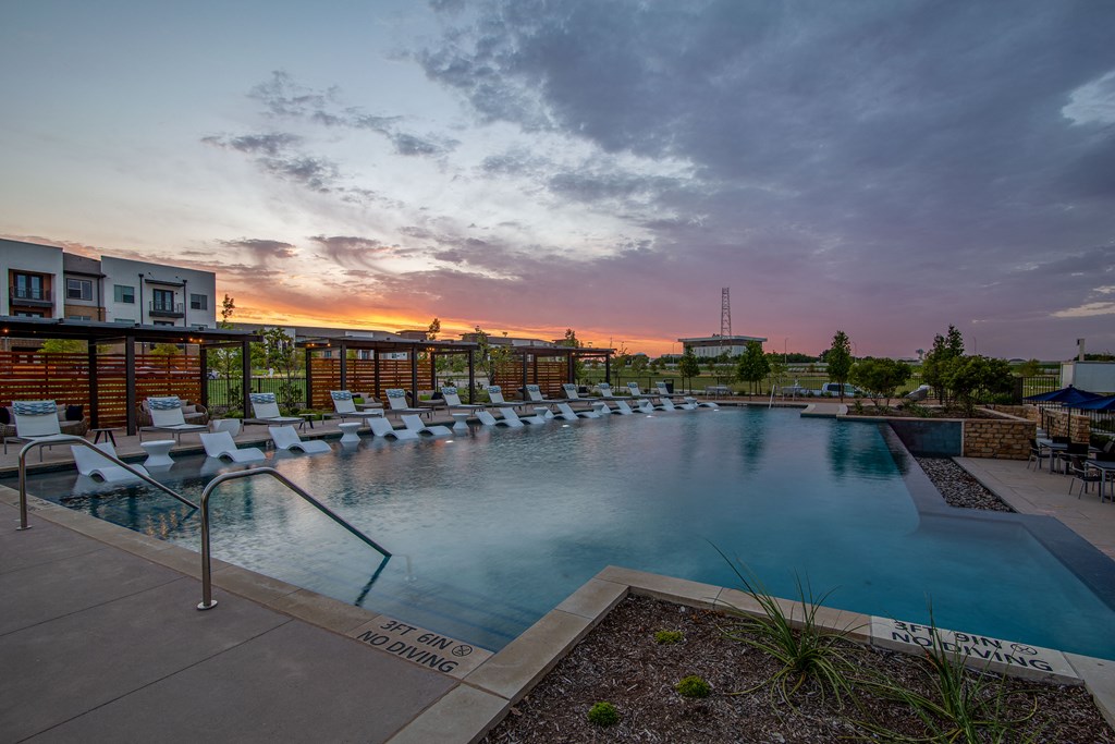 a swimming pool with lounge chairs at sunset at the grove resort and spa