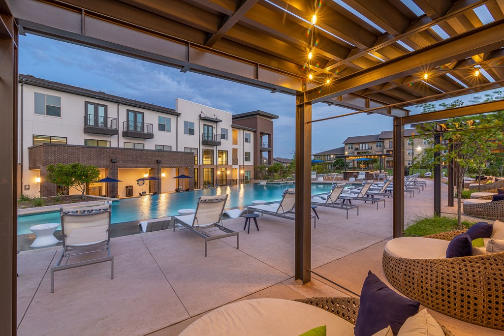 our apartments have a large pool and lounge area with chairs and tables