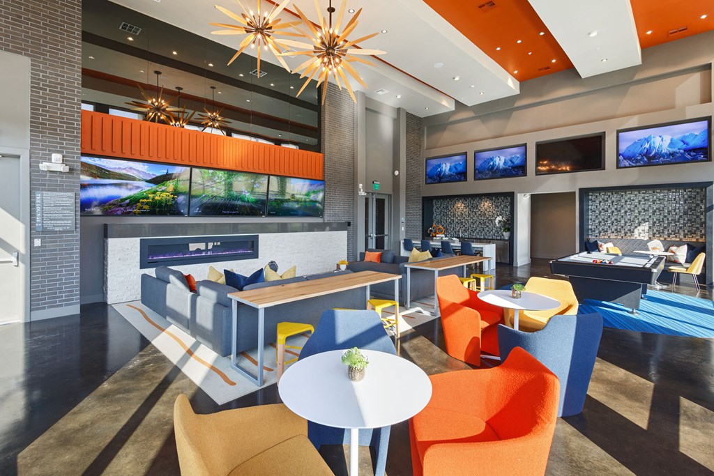 a lounge area with chairs and tables and a fireplace