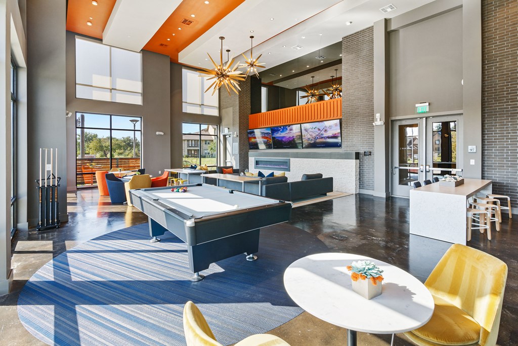 a clubhouse with tables and chairs and a pool table