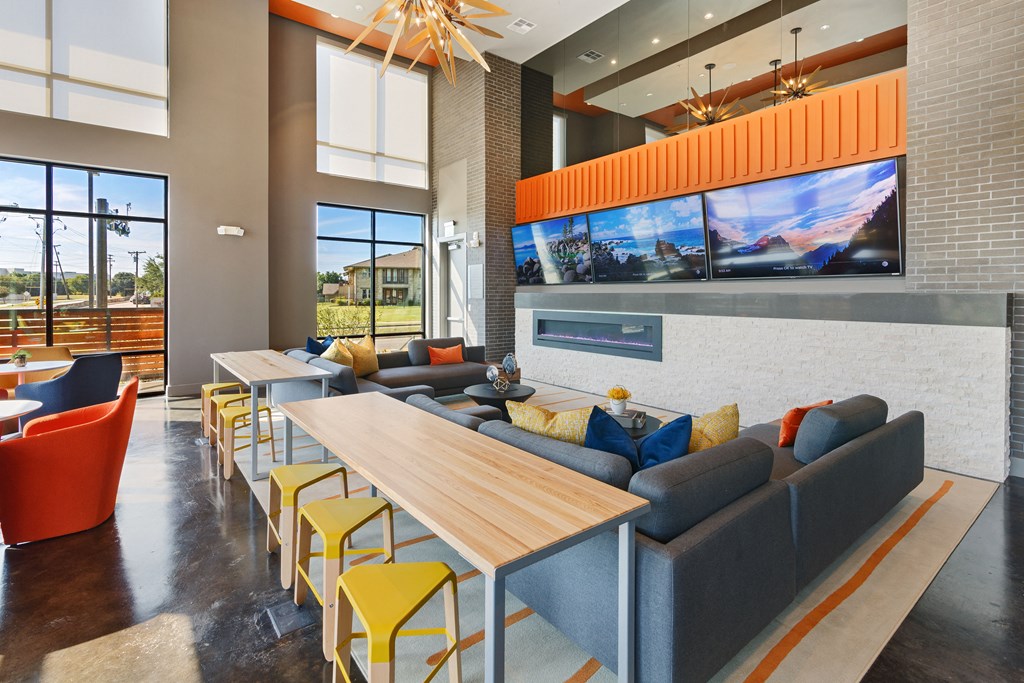 a lounge area with couches tables and chairs and large windows