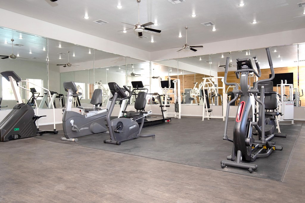 a large fitness room with treadmills and ellipticals