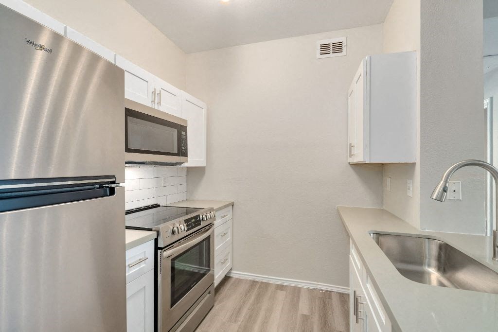 a kitchen with stainless steel appliances and white cabinets