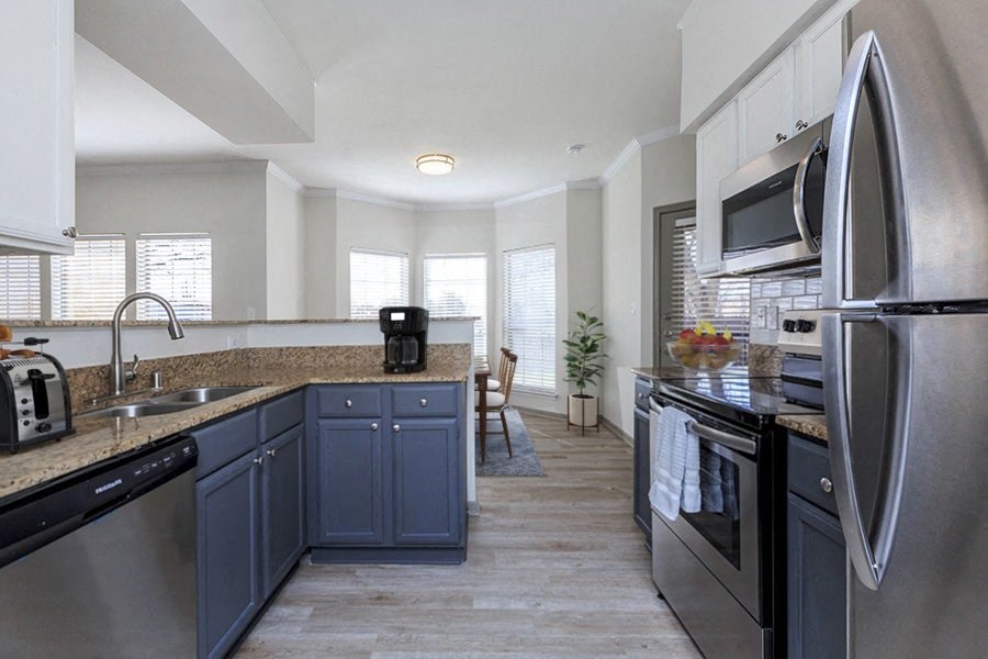 A kitchen with a black fridge and a black oven.