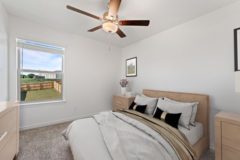 A bedroom with a large bed and a ceiling fan.