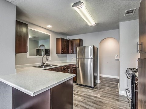 A kitchen with a stainless steel refrigerator and a white countertop.