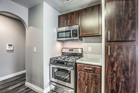 A kitchen with a stove top oven and microwave above it.