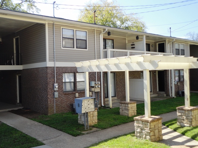 a pergola in front of an apartment building