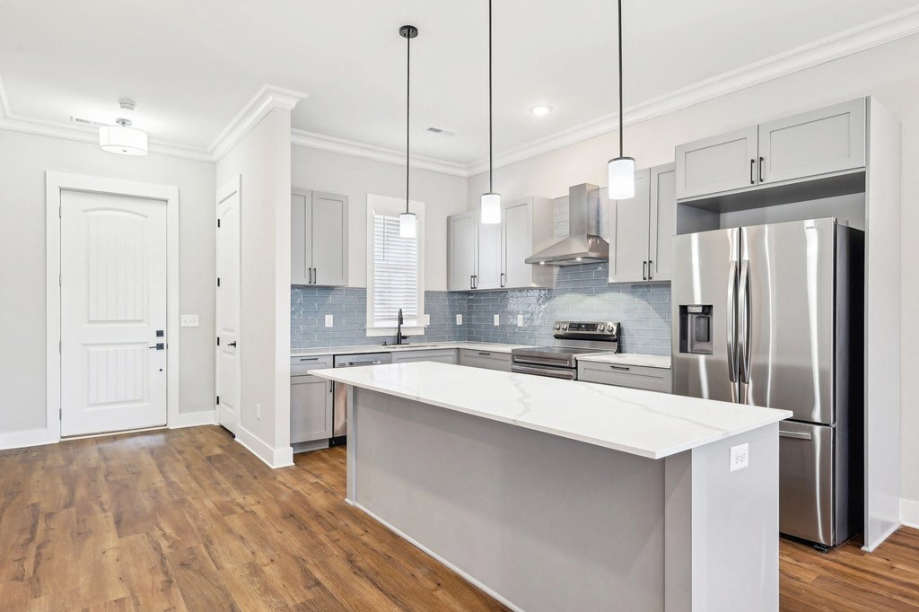 A modern kitchen with a large island and stainless steel appliances.