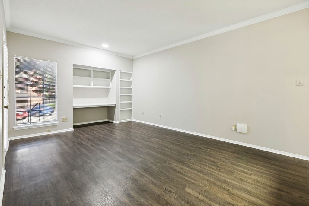 A room with wooden flooring and white walls.