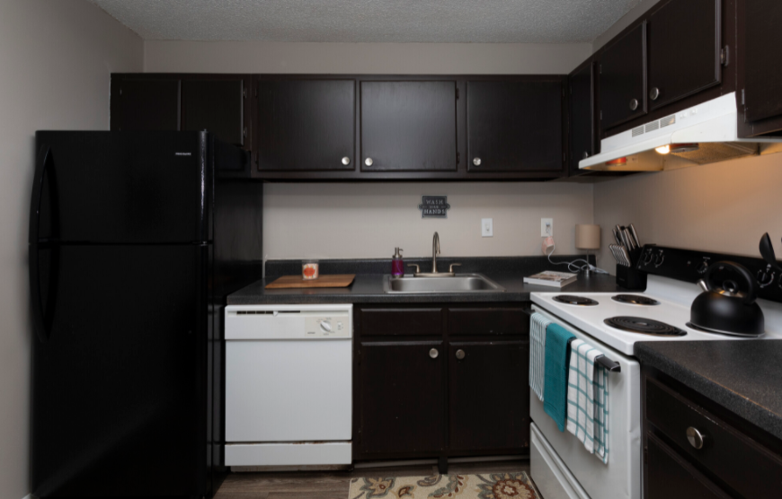 a kitchen with black cabinets and white appliances
