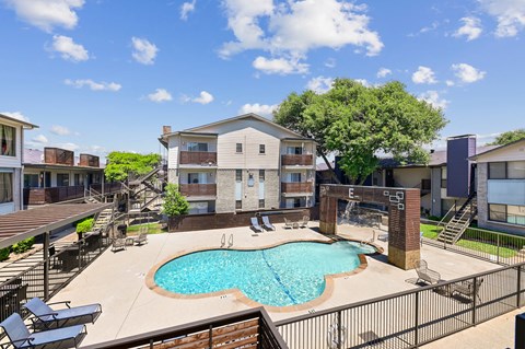 A swimming pool in a backyard surrounded by a fence.