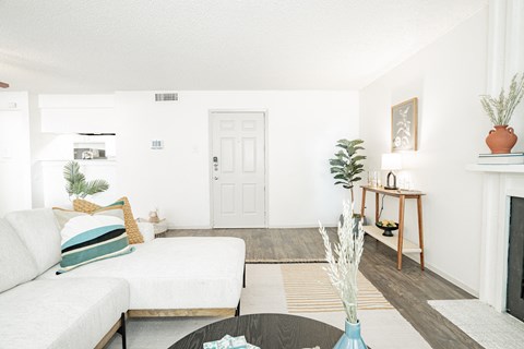 a living room with a white couch and a table    and a fireplace