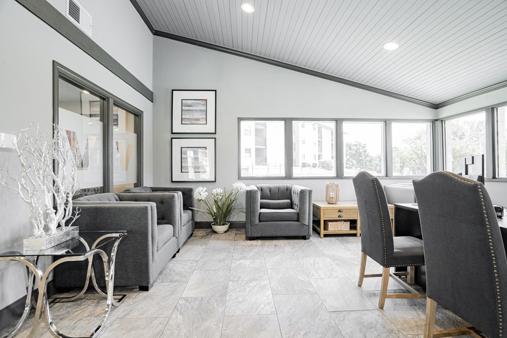 a living room with gray couches and chairs and a large window