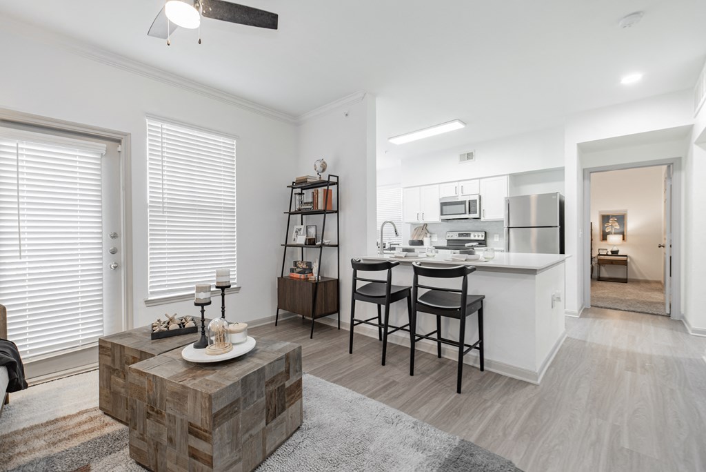 a living room with a couch and a kitchen with a table and chairs