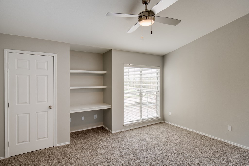 a bedroom with a ceiling fan and a window