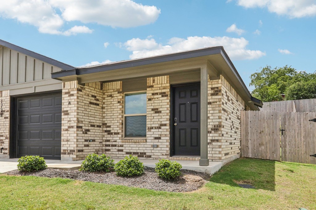 A house with a black door and a grey garage door.