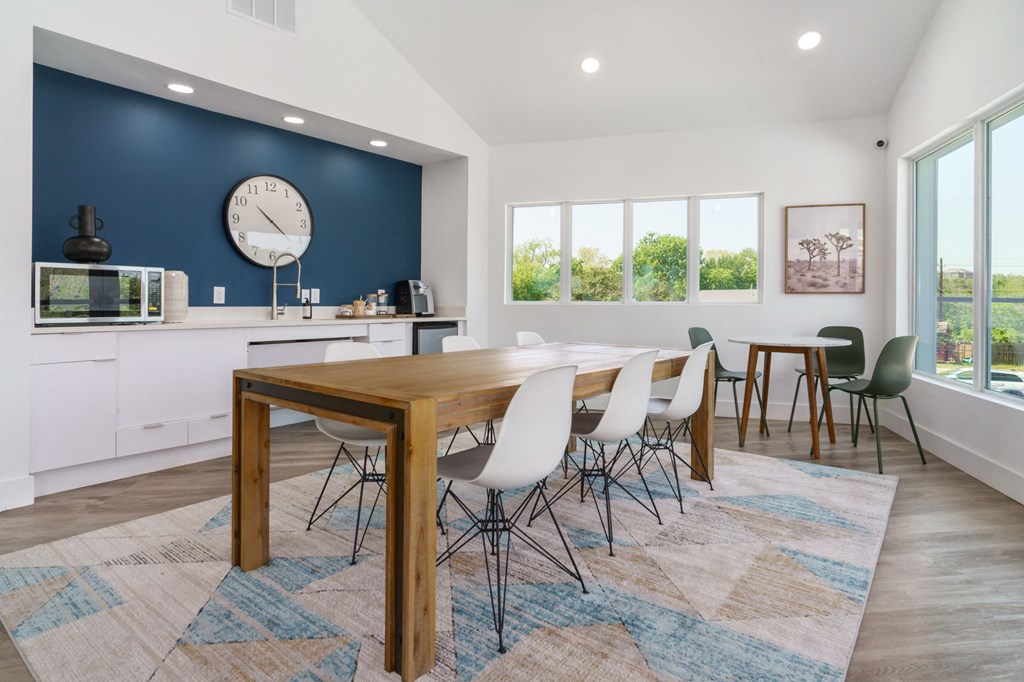 a dining room with a table and chairs and a clock on the wall