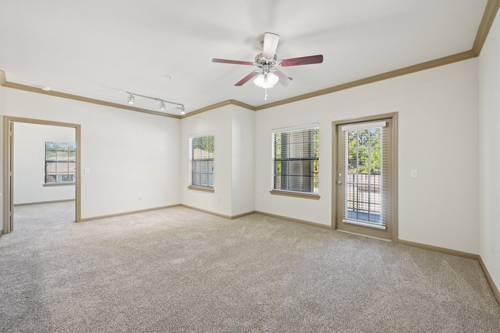 A room with a ceiling fan and carpeted floor.