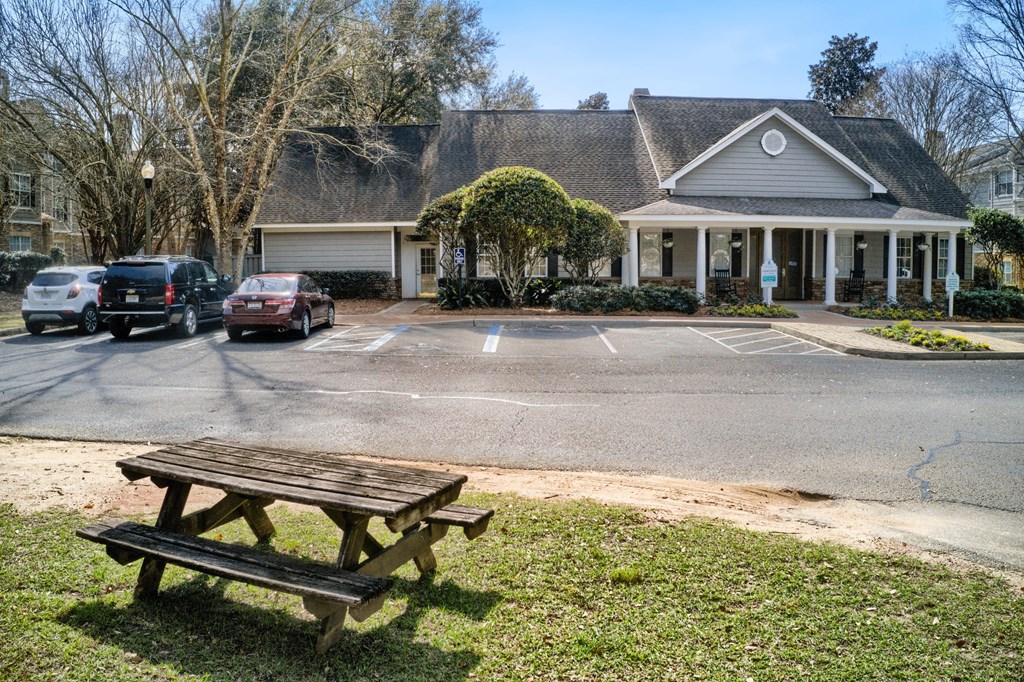 a picnic table in a parking lot in front of a house