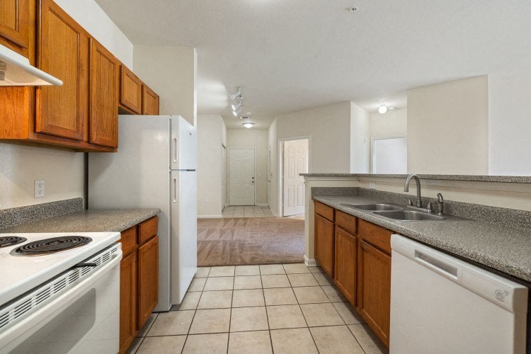 an empty kitchen with a stove refrigerator and sink