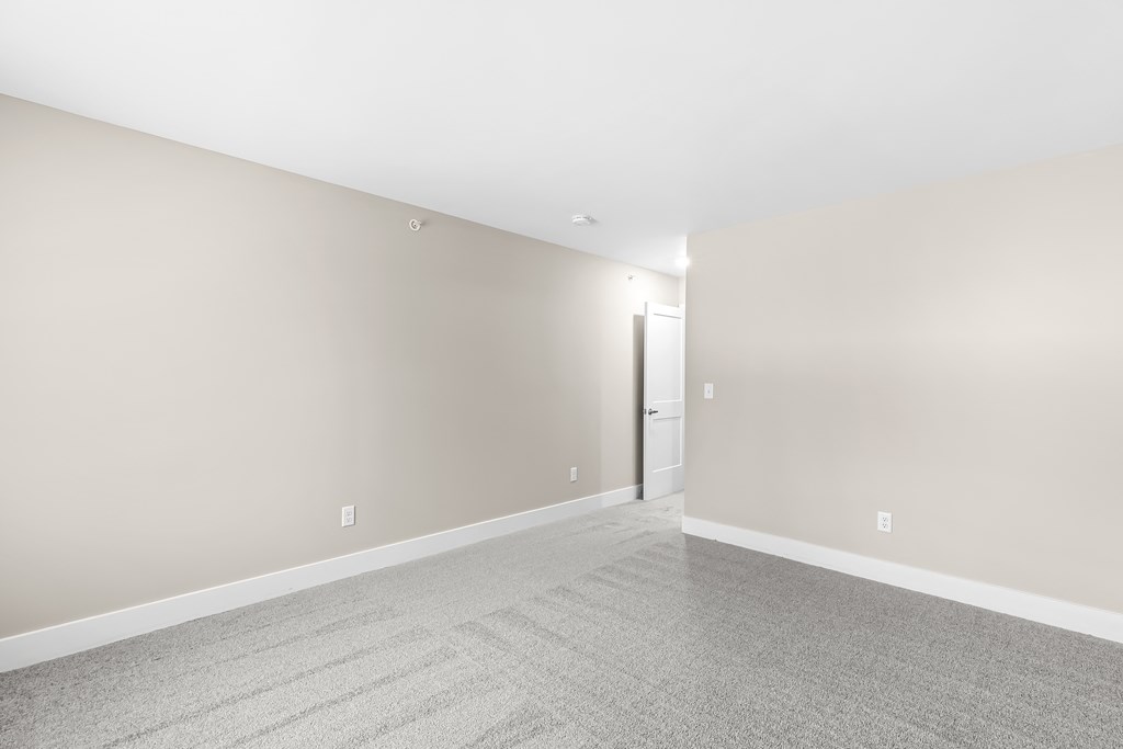 a living room with a carpeted floor and white walls