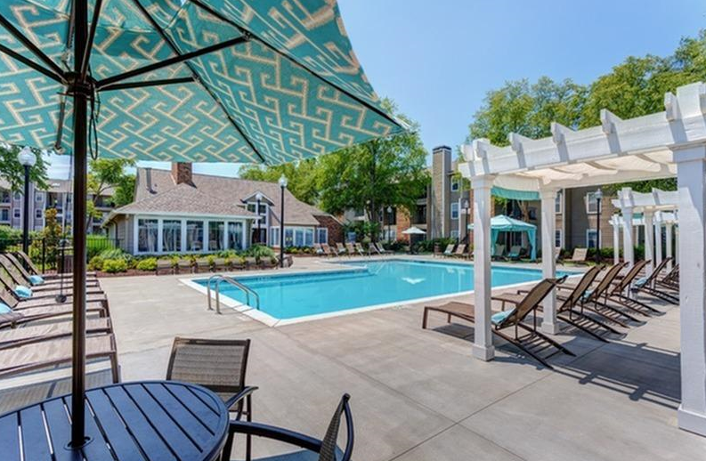 a swimming pool with chairs and umbrellas around it