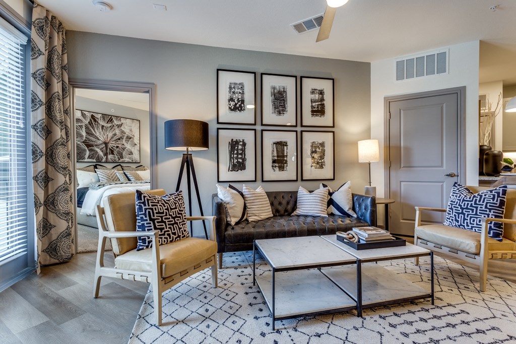 a living room with a couch and chairs and a coffee table