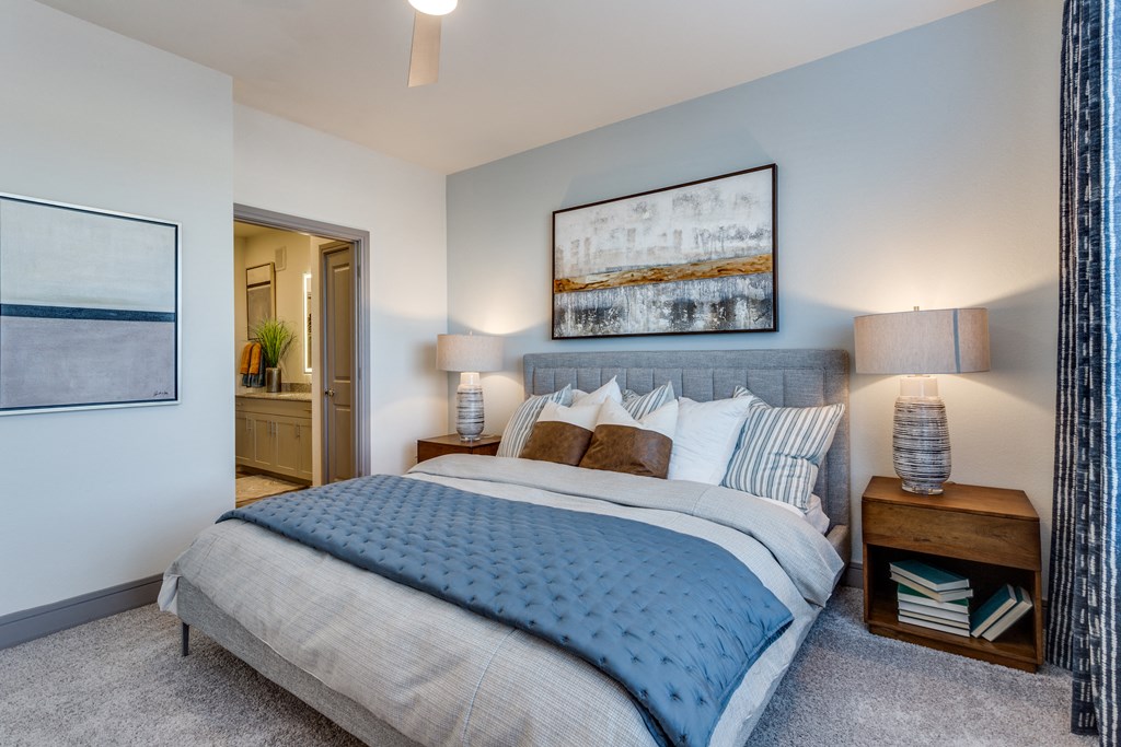 a bedroom with a large bed and a view of the bathroom