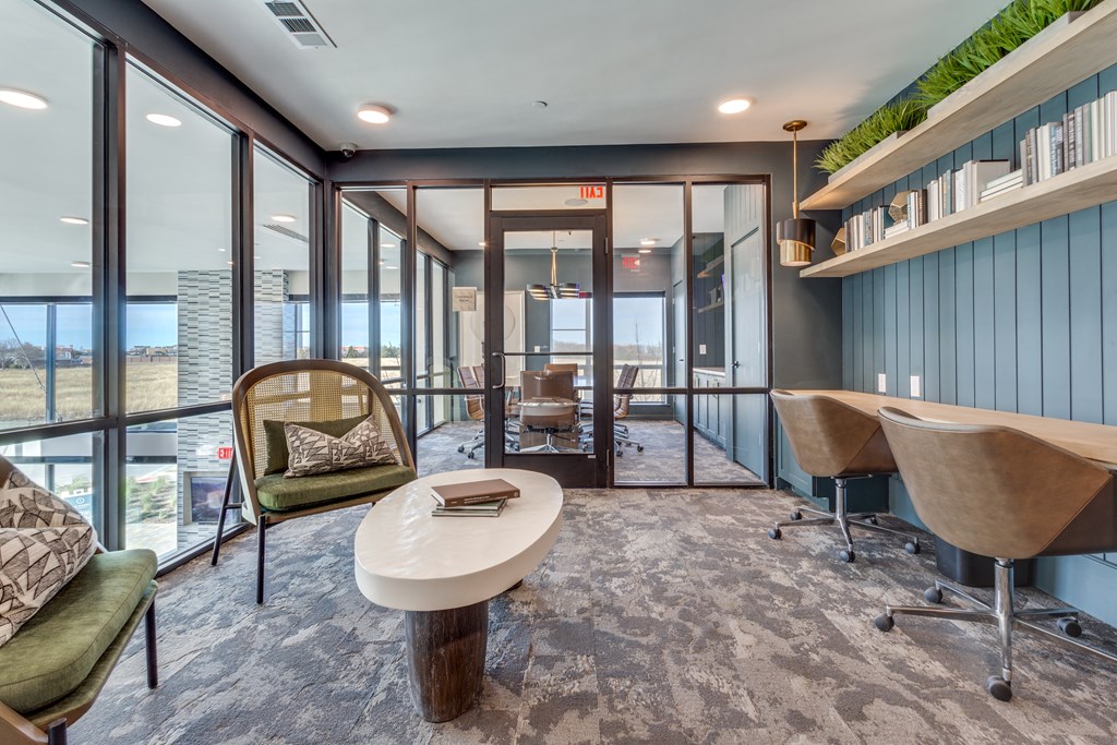 a conference room with a table and chairs and large windows