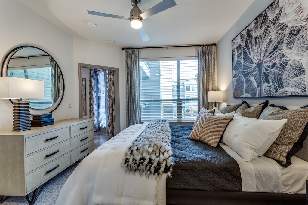a bedroom with a large bed and a ceiling fan