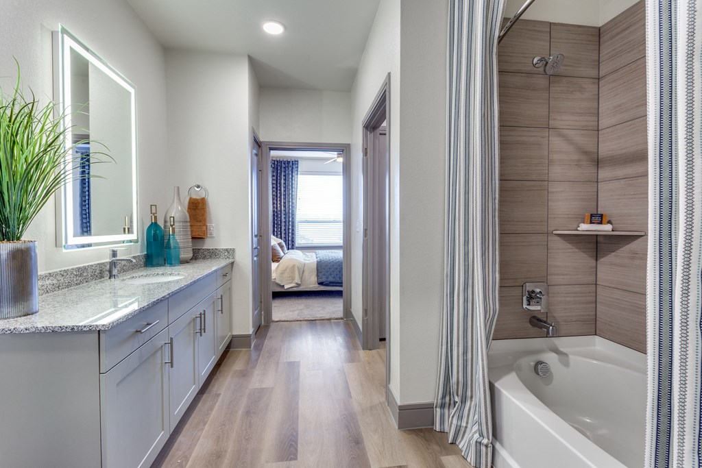 a bathroom with a tub and a shower and a sink