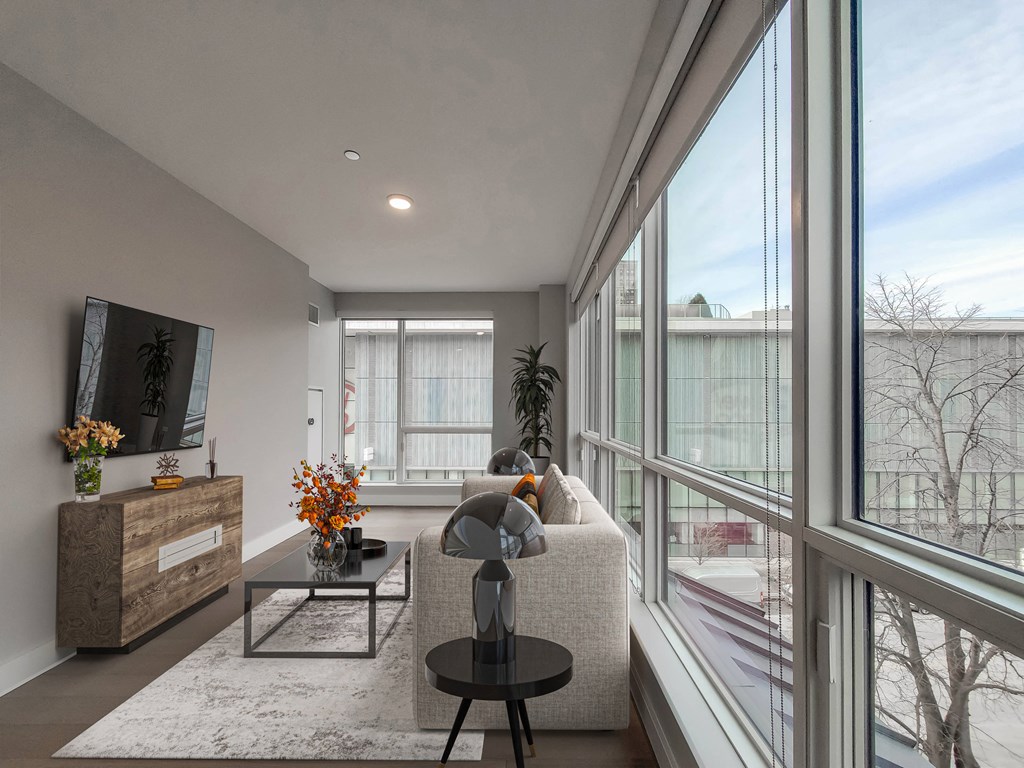 A modern living room with a large window overlooking a snowy landscape.