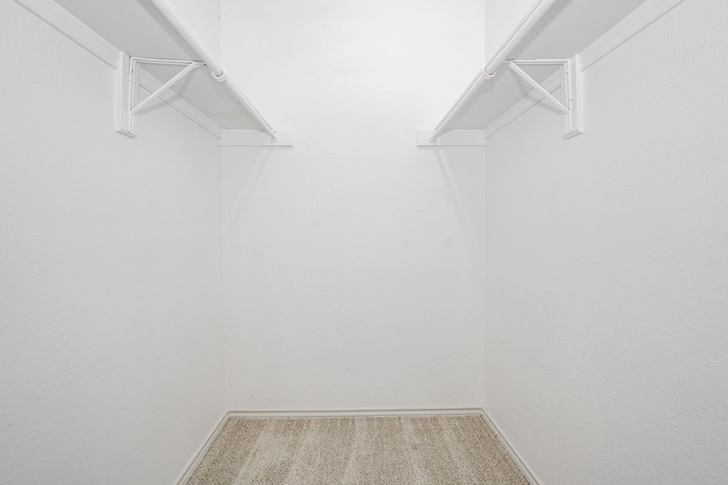 an empty room with white walls and two white shelves