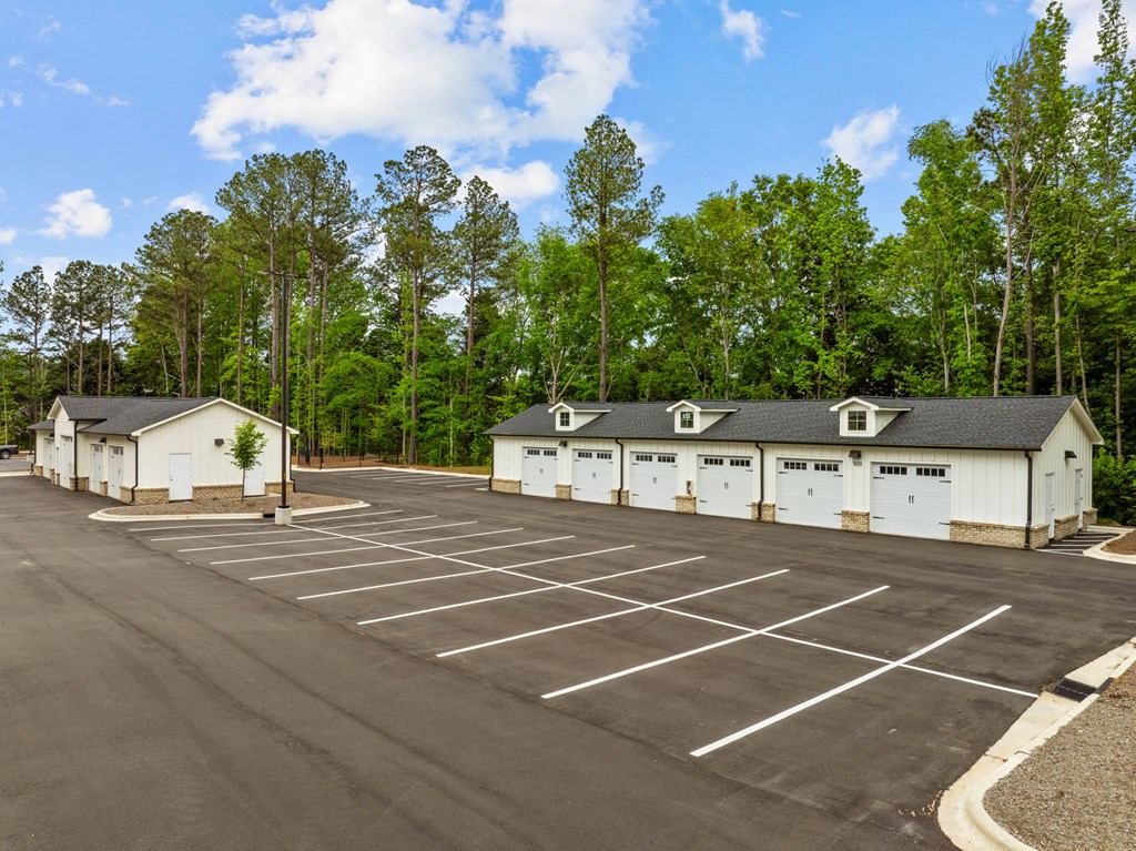 a parking lot with parking garages in front of trees