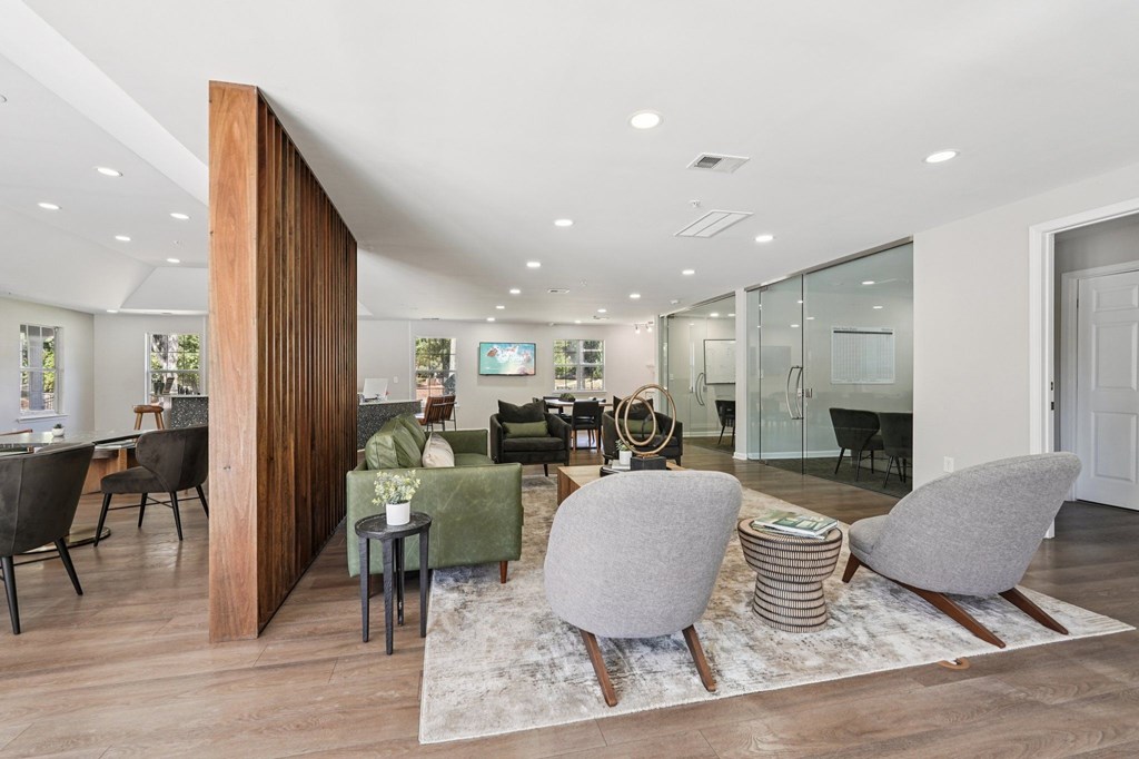 A modern living room with a wooden partition and a glass wall.