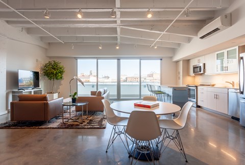 A modern open plan living and kitchen area with a table and chairs.