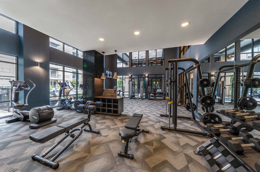 a spacious fitness center with cardio machines and weights