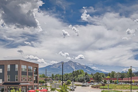 a view of a mountain and a parking lot with a building in the foreground