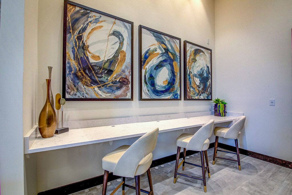 a home office with three paintings on the wall