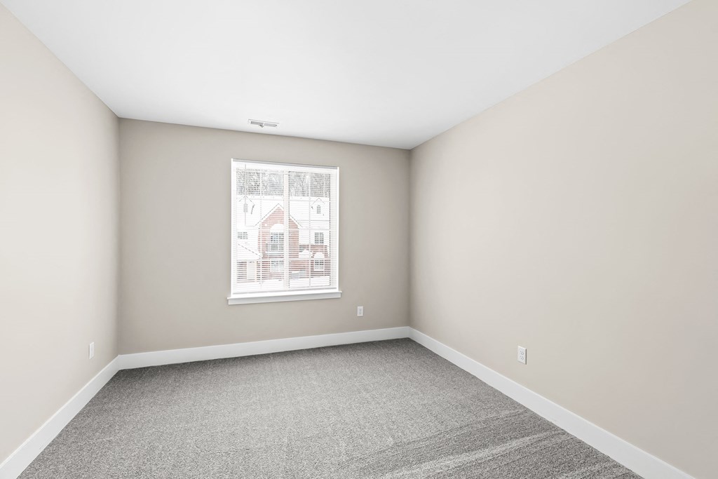 an empty room with white walls and a window