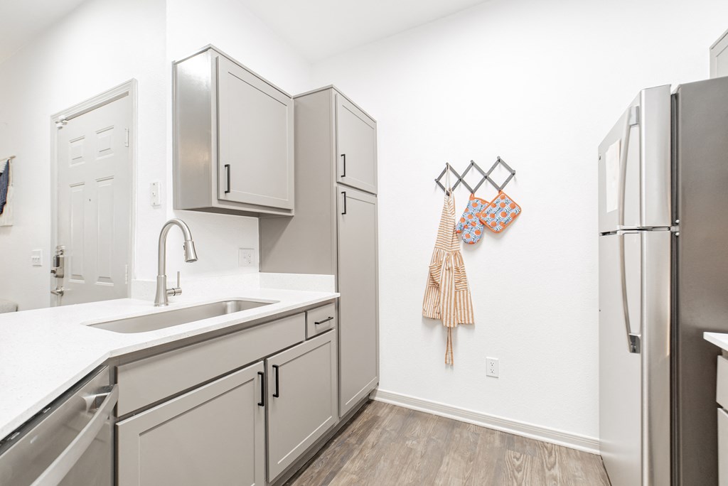 a kitchen with white cabinets and stainless steel appliances and a stainless steel refrigerator