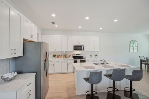 A modern kitchen with white cabinets and a central island.
