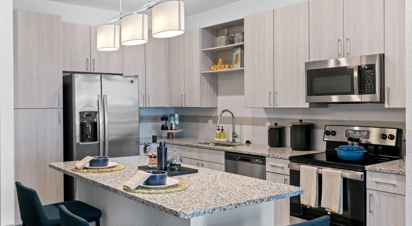 A kitchen with a granite countertop and stainless steel appliances.