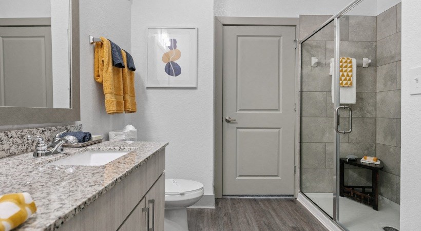 A bathroom with a toilet, sink, and shower.