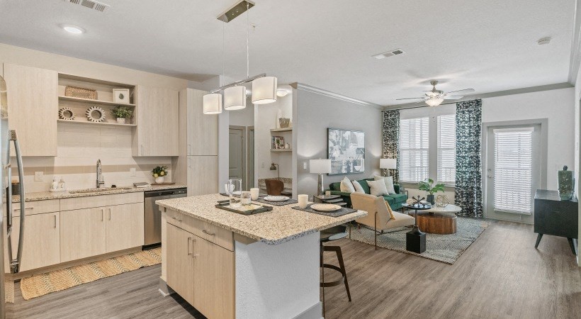 A modern kitchen with a large island and a dining area.