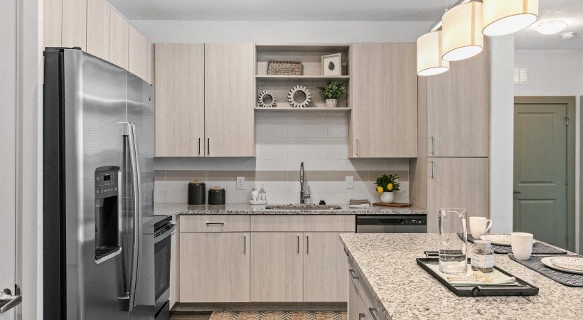 A modern kitchen with a refrigerator, sink, and countertop.