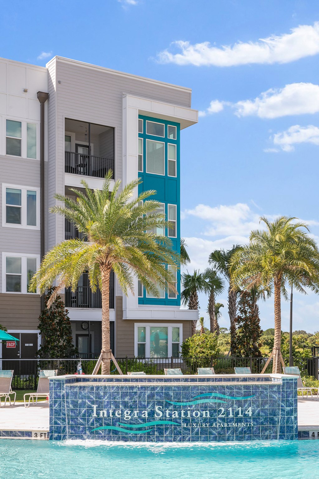 A modern apartment building with a pool in front.