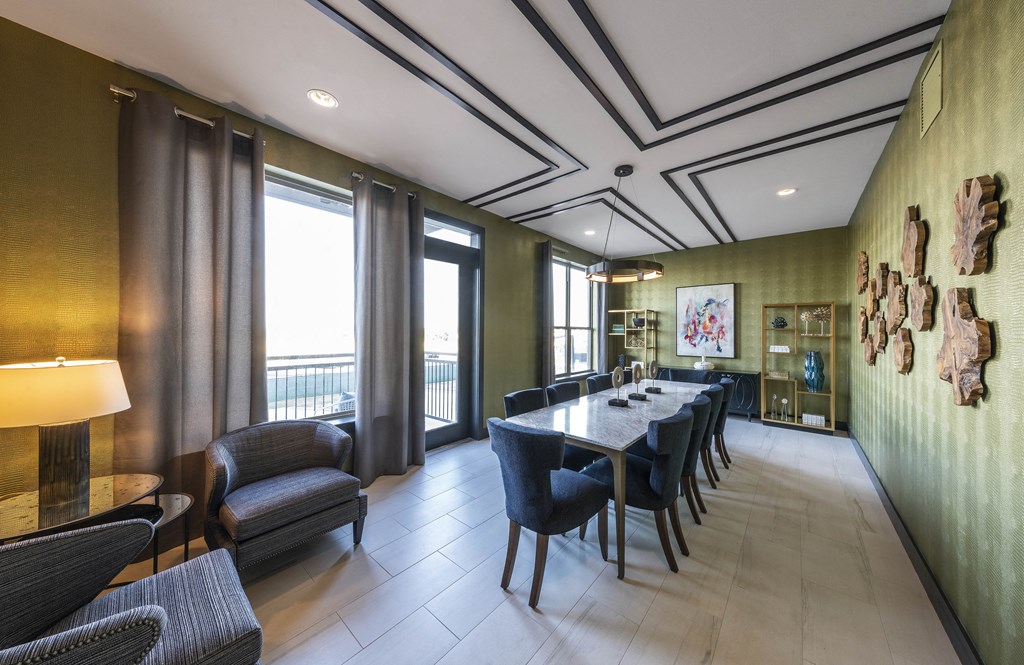 a long table with chairs in a room with large windows